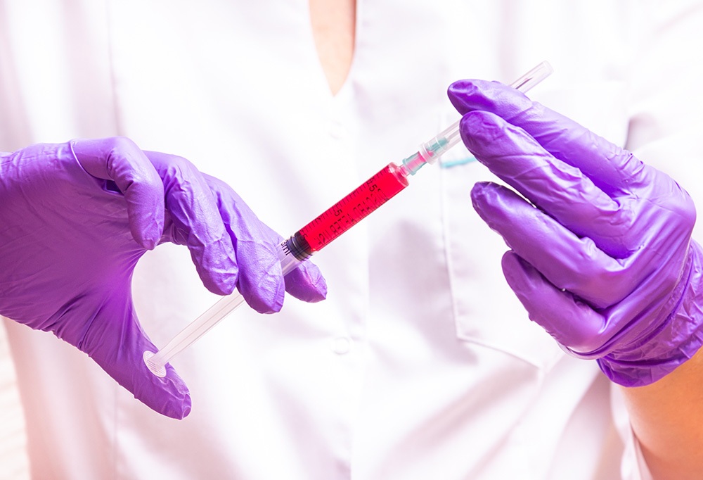 Woman hand holding syringe and ampule