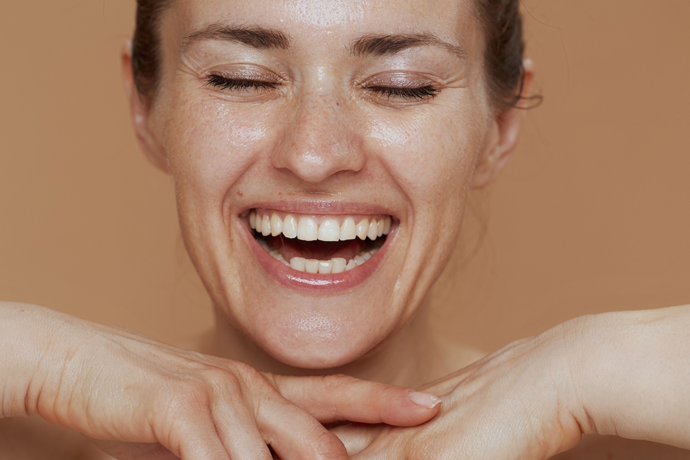 smiling woman with wet face washing smiling woman with wet face washing