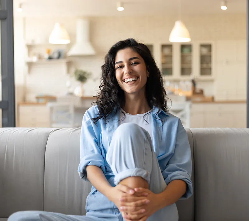 young woman smiling sitting on the couch young woman smiling sitting on the couch