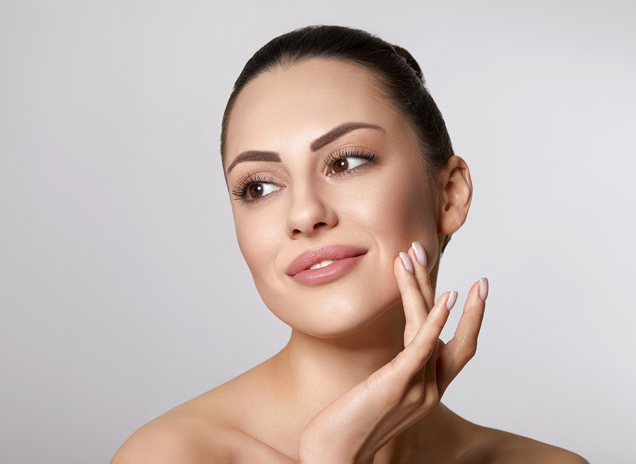 Woman with beauty face touching healthy facial skin portrait